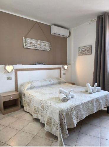 a bedroom with a bed with two towels on it at Il Melangolo in SantʼAntìoco