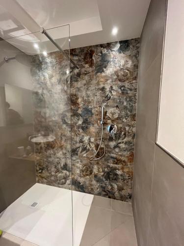 a bathroom with a shower with a stone wall at Ca' Bertera in Ledro