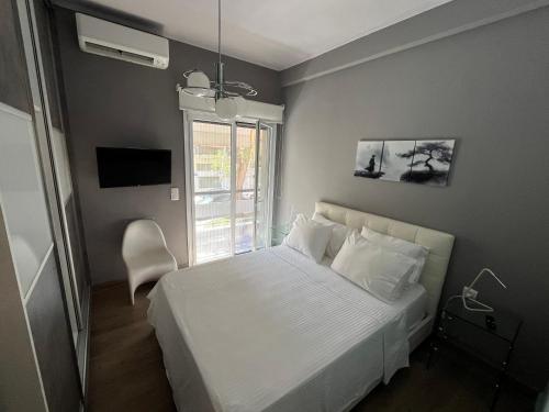 a bedroom with a white bed and a window at Luxury Serenity in Piraeus