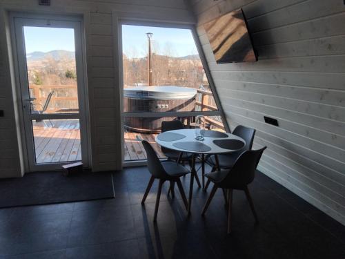 a table and chairs in a room with a large window at A Frame HAPPINESS in Yasinya