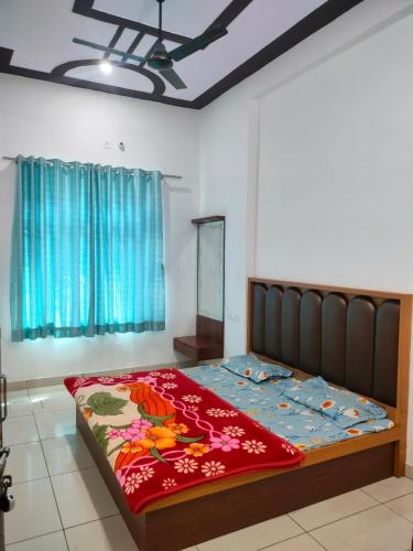 a bedroom with a large bed with a red blanket at Hotel Keshav in Rīngas