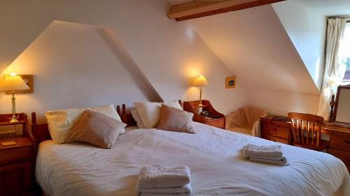 a bedroom with a white bed with two towels on it at Montacute Country Tearoooms in Montacute