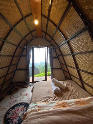 a bed in a round room with a window at Giri Garden Sunset Glamping in Gitgit