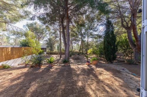 a yard with trees and potted plants and a fence at Luxe Vista in Serra