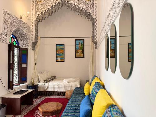a living room with a blue couch and a bed at Riad El abrar in Salé