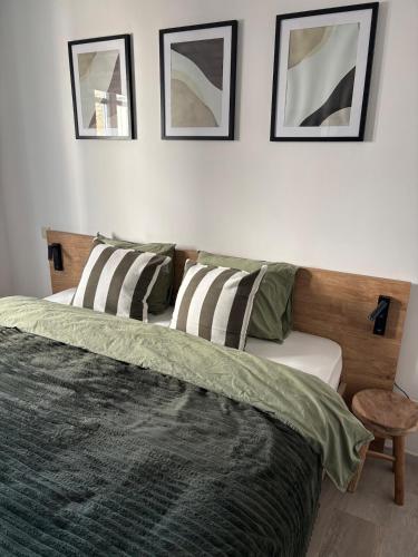 a bedroom with a bed and three pictures on the wall at Appartement chez pépite in Namur