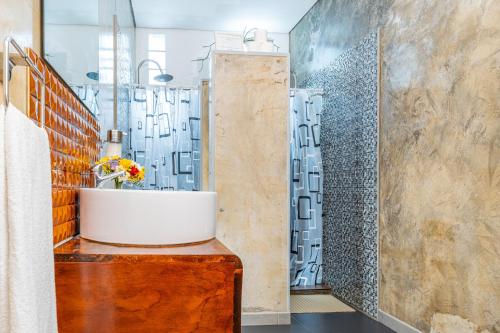 a bathroom with a sink and a shower at A-Típica GuestHouse in Ponta Delgada