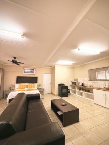 a large living room with a couch and a bed at Green Grove Villa in Centurion