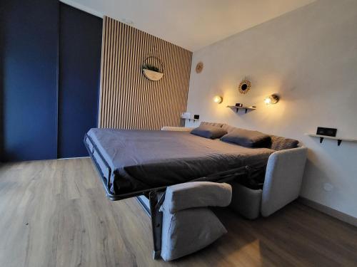 a bedroom with a large bed and a couch at Studio avec terrasse in Amiens