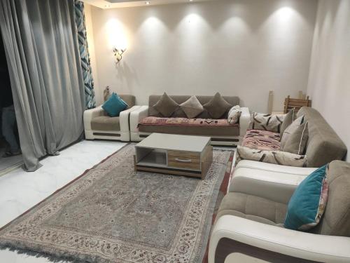 a living room with couches and a coffee table at بورتو السخنه الاهرامات in Banī Ghālib