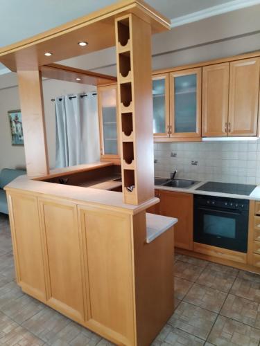 a kitchen with wooden cabinets and black counter tops at Takis House in Gavrio