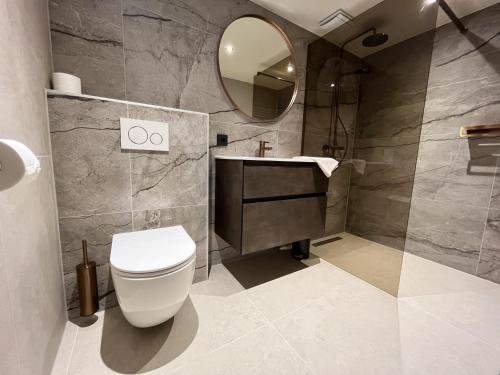 un bagno con un water, un lavandino e uno specchio di Appartementen het Centrum a Domburg