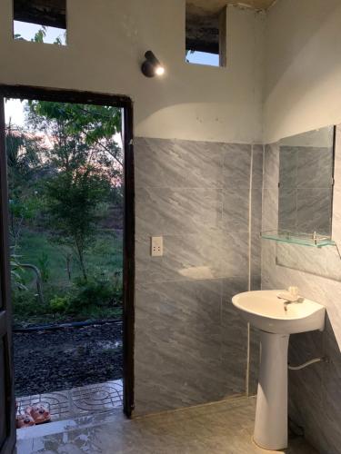 a bathroom with a sink and a shower with a window at Homestay tay in Xã Trảng Bôm