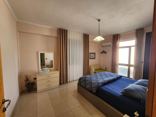 a bedroom with a bed and a dresser and a mirror at Jozi Kaiser Apartment 2 in Durrës