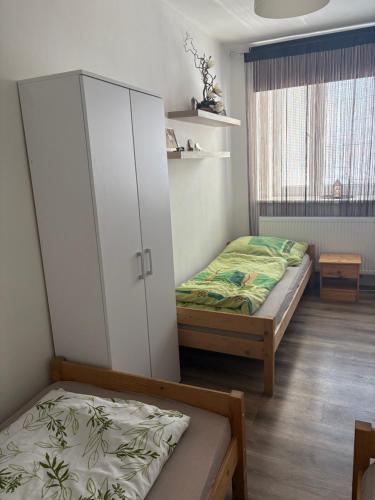 a bedroom with two beds and a cabinet at Ubytování Linda in Klášter Hradiště nad Jizerou