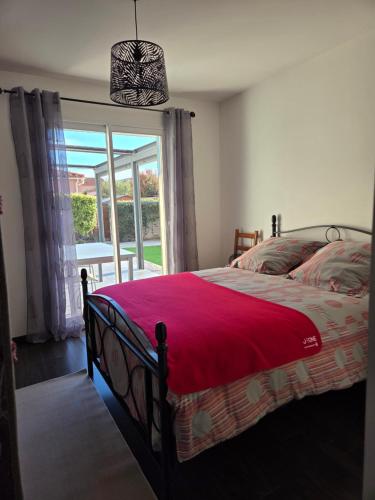 a bedroom with a bed and a large window at Chez Titelle in Saint-Laurent-de-la-Salanque