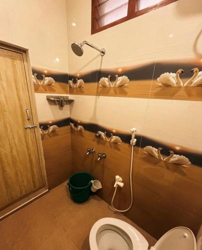 a bathroom with a toilet and a shower with towels at Gravity Groups AARA Residency - Near Jipmer in Puducherry Airpoert