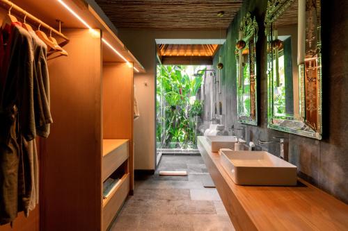 a bathroom with two sinks and a large window at La Reserve 1785 Canggu - Adults Only in Canggu