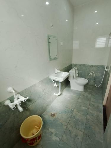 a bathroom with a toilet and a sink and a mirror at RV Comforts in Siruvāchchūr