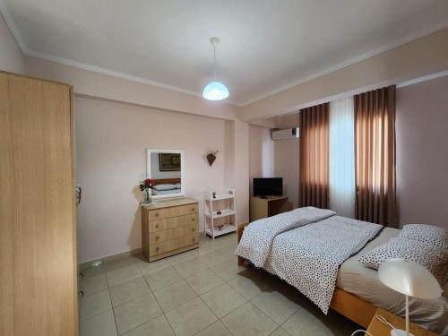 a bedroom with a bed and a dresser and a television at Jozi Kaiser Apartment 3 in Durrës