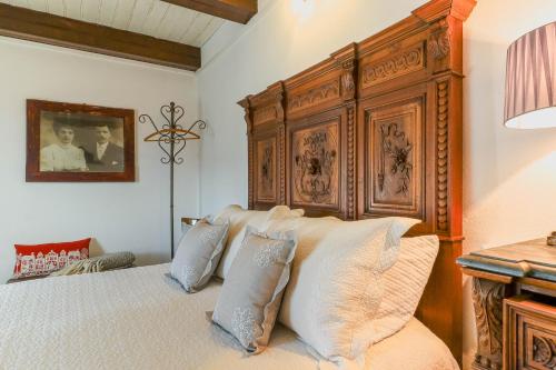 a bedroom with a large wooden bed with pillows at Bnbook Ca Du Val in Falmenta