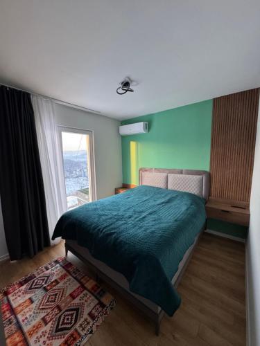 a bedroom with a green bed and a window at Villa Sunny Alley - Sunčani Sokak in Sarajevo