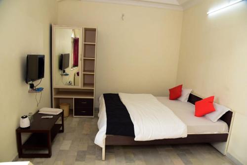 a bedroom with a bed with red pillows and a mirror at Hotel Royal Maithan International in Garphalbāri