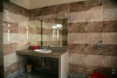 a bathroom with a sink and a shower at Hotel Royal Maithan International in Garphalbāri