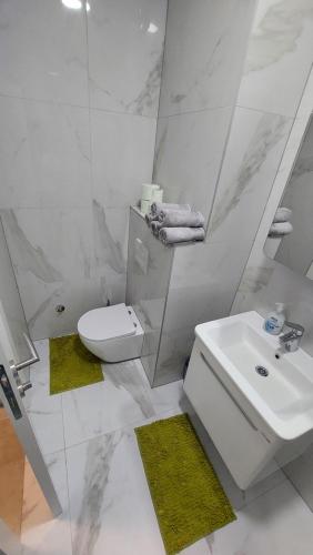 a white bathroom with a sink and a toilet at Apartman Stan Laktasi in Laktaši
