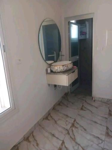 a bathroom with a sink and a mirror on the wall at Romantique place in Mahdia