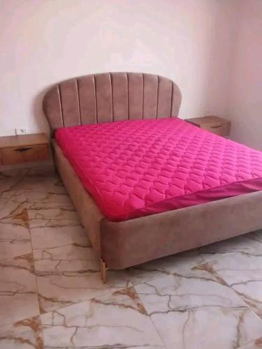 a bed in a room with a pink mattress at Romantique place in Mahdia