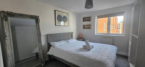 a bedroom with a bed with a mirror and a window at Perfect for WMC, principality stadium and Utilita Arena in Cardiff