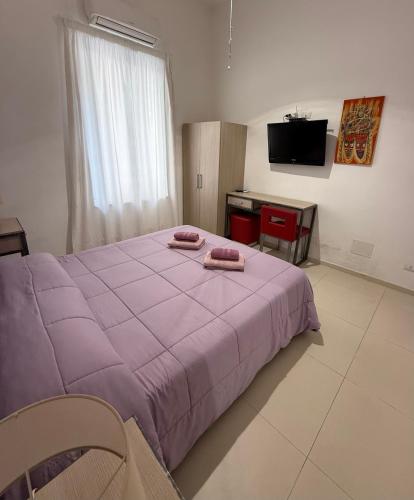 a bedroom with a large purple bed and a desk at Casa Bucalo 2, Taormina in Taormina