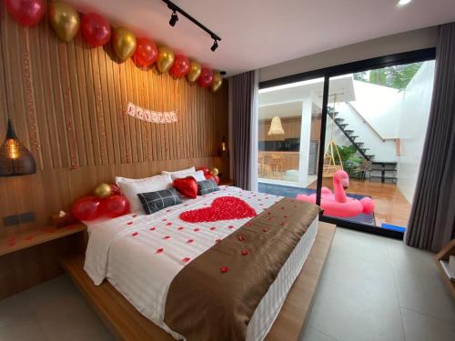a bedroom with a large bed with balloons on it at Agarra Villa in Yogyakarta