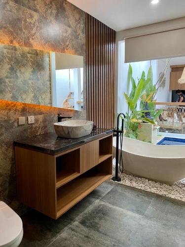 a bathroom with a sink and a bath tub at Agarra Villa in Yogyakarta