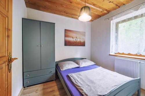 a small bedroom with a bed and a window at Chata Dolinka in Liptovské Revúce
