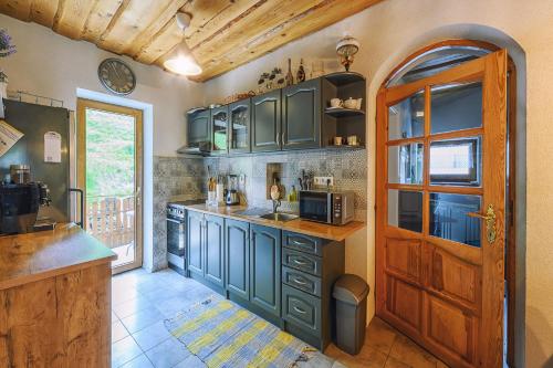 a kitchen with green cabinets and a wooden door at Chata Dolinka in Liptovské Revúce