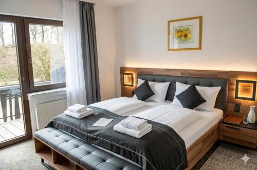 a bedroom with a large bed with towels on it at Hotel Kühns Mühle in Oestrich-Winkel