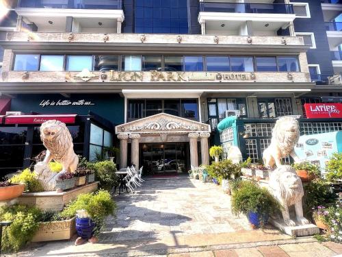 a building with two lion statues in front of it at Lion Park Suites & Residence Hotel in Aydın