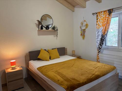 a bedroom with a bed with yellow pillows and a window at Maison chez Louis in Asuel