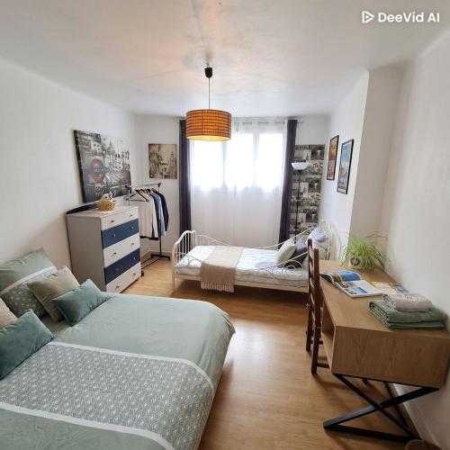 a bedroom with two beds and a table in it at Spacieux T3 lumineux dans quartier historique avec wifi in Redon