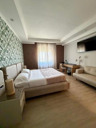 a large bedroom with a bed and a couch at Hotel Daytona Palace in Casoria