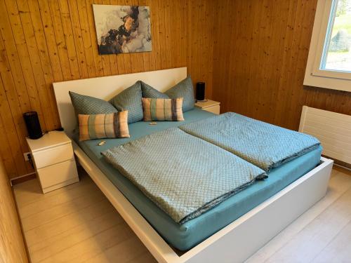 a bed in a room with wooden walls at See und Berge Cozy in Faulensee