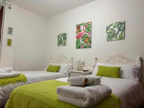 two beds in a room with green and white at Apartamento Estela in Combarro