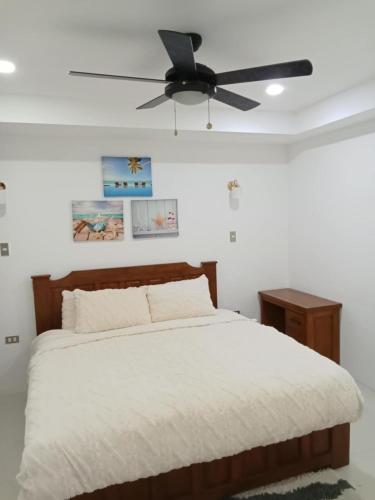 a bedroom with a bed with a ceiling fan at Iluka 2- By the Bay in Puerto Galera