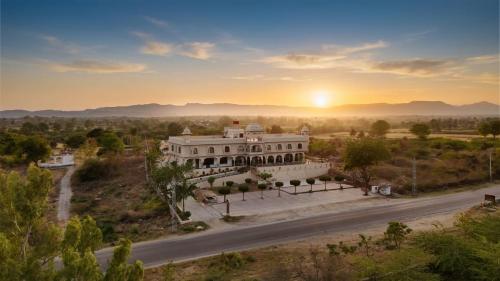 an aerial view of a mansion with the sunset in the background at Jaisamand Garh Resort in Udaipur