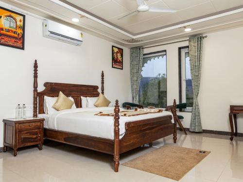 a bedroom with a bed and a large window at Jaisamand Garh Resort in Udaipur