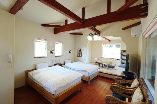a bedroom with two beds and a television in it at 天からの贈り物 VillaMontpetre in Kirishima