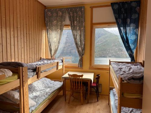 a bedroom with bunk beds and a table and a window at Hellesylt Hostel in Hellesylt