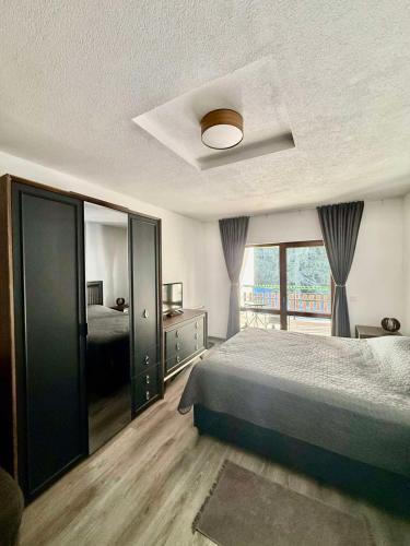 a bedroom with a bed and a window at Вила Планински перли, Дом 11 in Stoykite